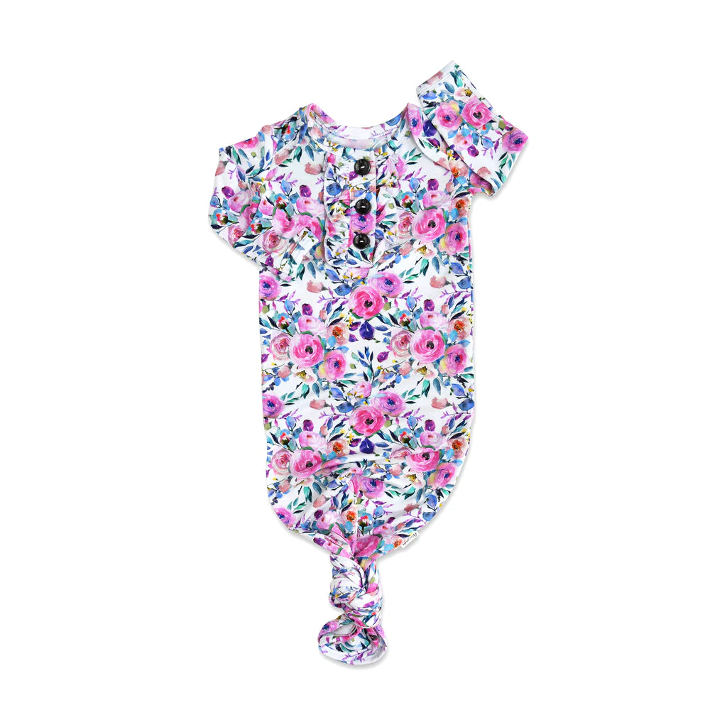 Vivienne Ruffle Baby Gown from Gigi & Max. Print is a pink and purple watercolor floral on a white background. 